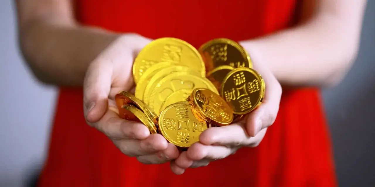 Hände halten einen Haufen glänzender Goldmünzen. Das ist ein schöner Gedanke, wann Urlaubsgeld!