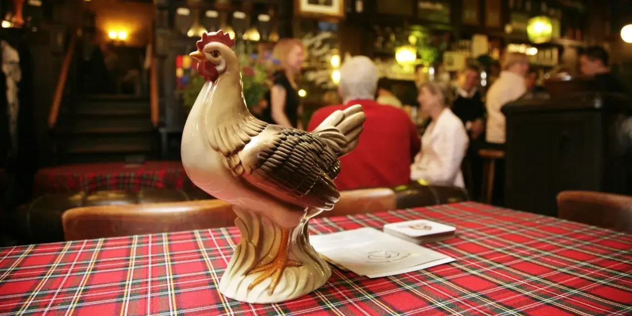 Keramikhähnchen auf kariertem Tisch in uriger Berliner Kneipe.