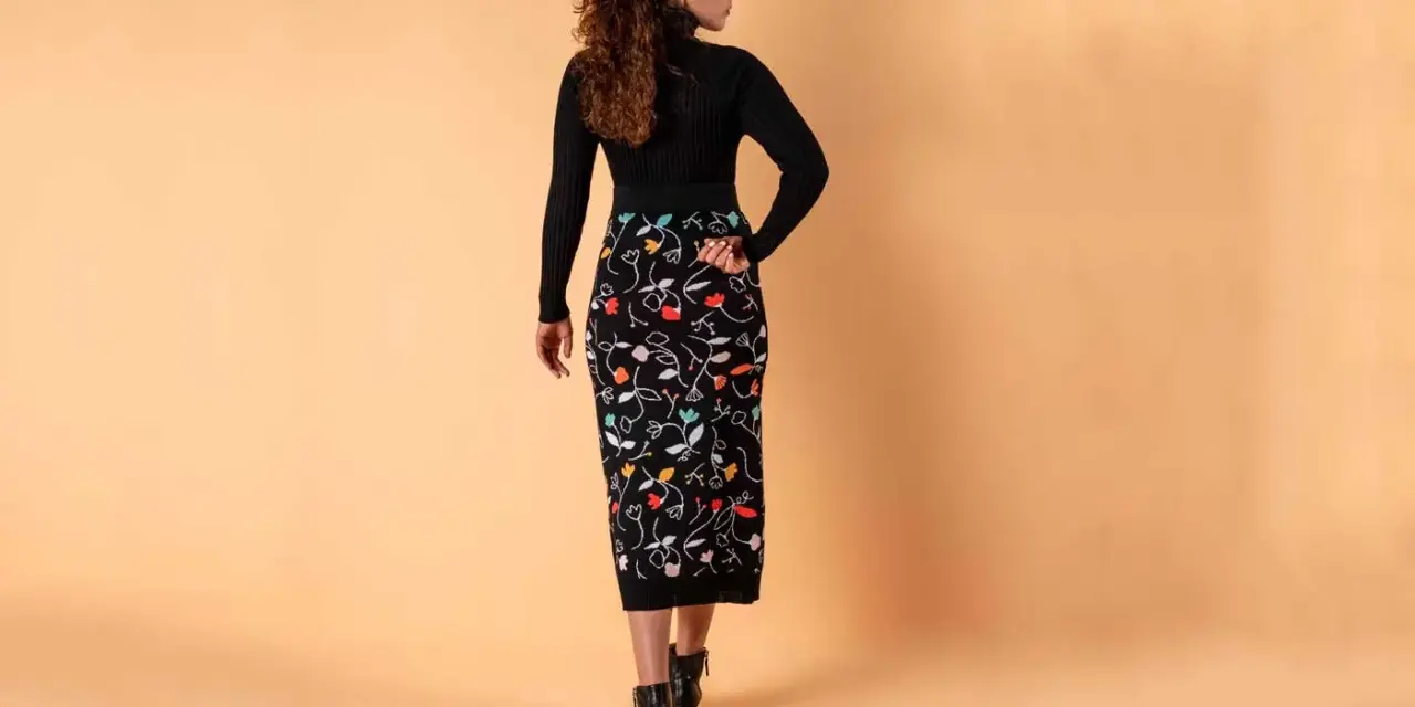 Mujer con falda lápiz negra estampada con flores de colores. Un ejemplo de los diversos tipos de faldas.