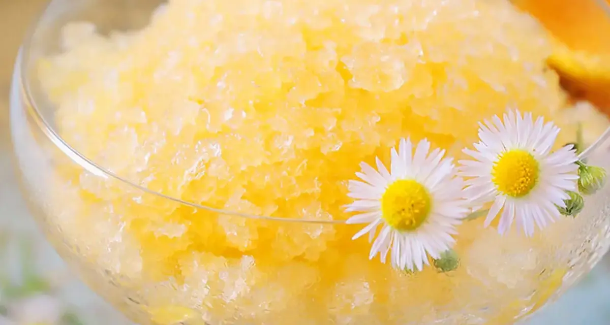 Erfrischendes Zitronen-Granita-Rezept in einem Glas, garniert mit Gänseblümchen. Perfekt für heiße Tage!