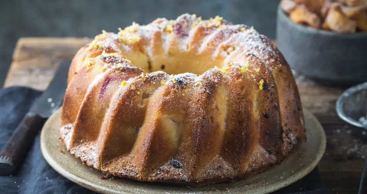 Wilgotna babka piaskowa Ewy Gotuje, posypana cukrem pudrem i skórką cytrynową, wygląda apetycznie.
