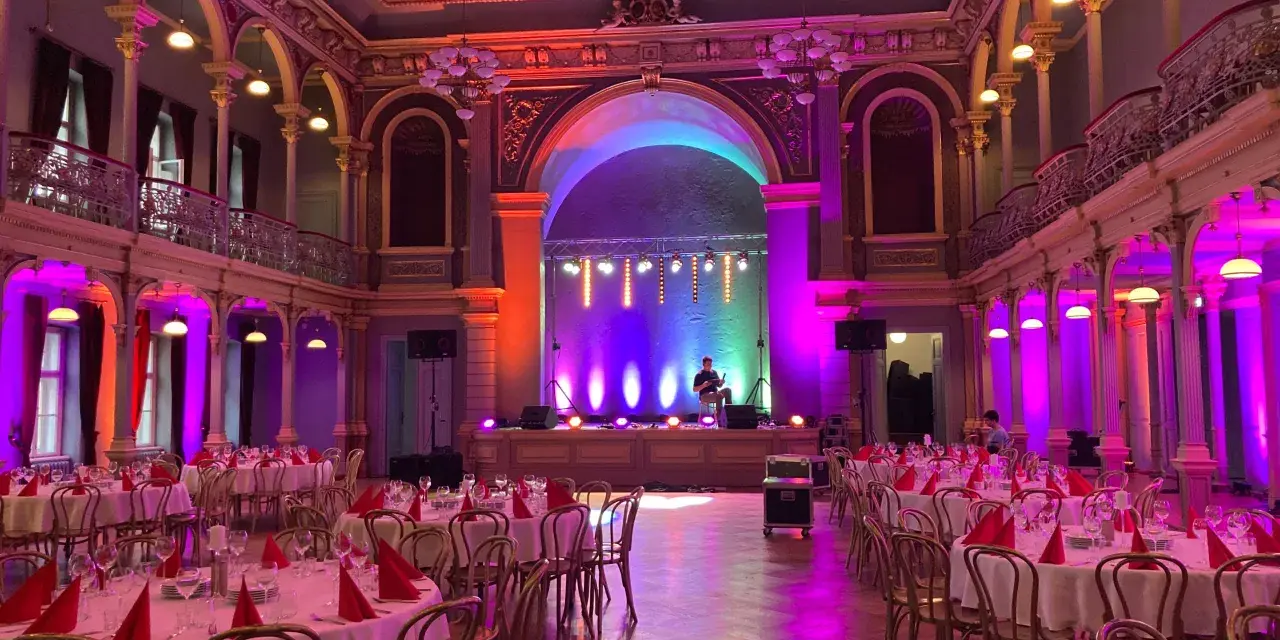 Elegancka sala balowa z oświetleniem tworzącym nastrój. Zastanawiasz się, ile kosztuje wynajęcie profesjonalnego dekoratora światłem na event?