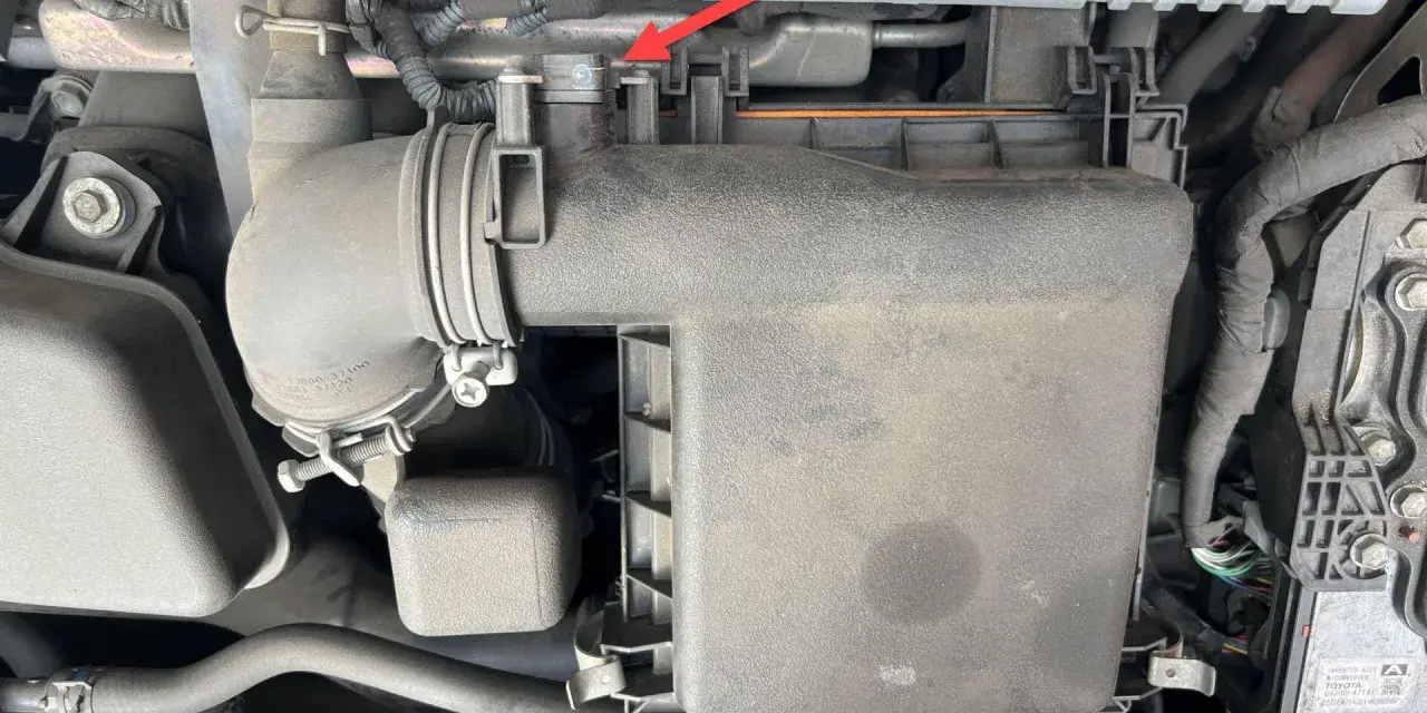A red arrow points to a clip on the air intake system of a Toyota Hybrid Synergy Drive. This could be related to a p0102 code.