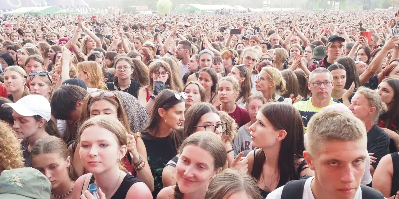 Tłum ludzi na lodz summer festival, z rękami w górze, cieszący się muzyką.