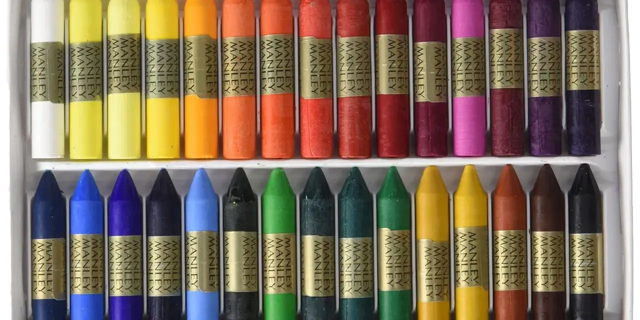 Ceras Manley de colores variados en una caja, dispuestas en dos filas.