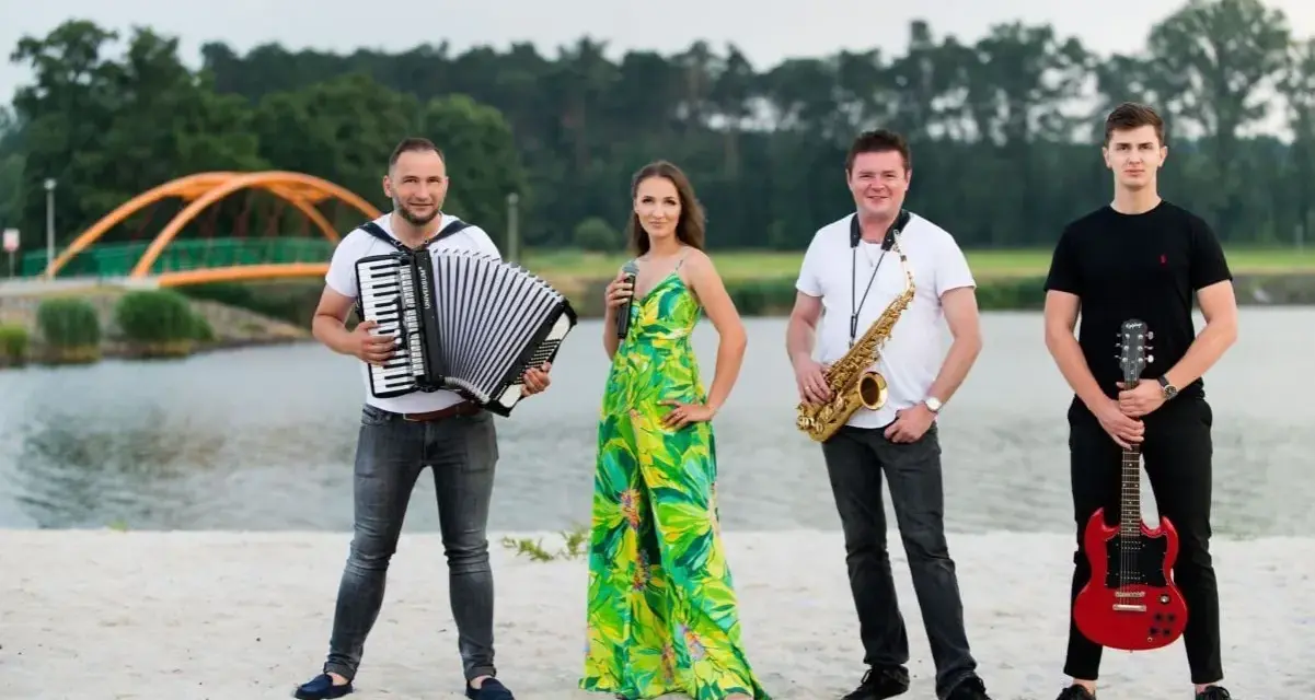 Teraz my - zespół skład: akordeonista, wokalistka, saksofonista i gitarzysta pozują na plaży.