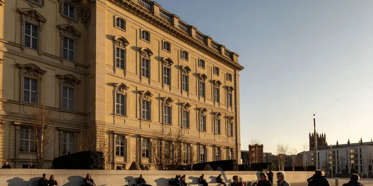 Sonnenlicht beleuchtet das barocke Gebäude, ein schönes Beispiel für kostenlose Orte, die man in Berlin besuchen kann. Menschen entspannen sich auf einer Bank.