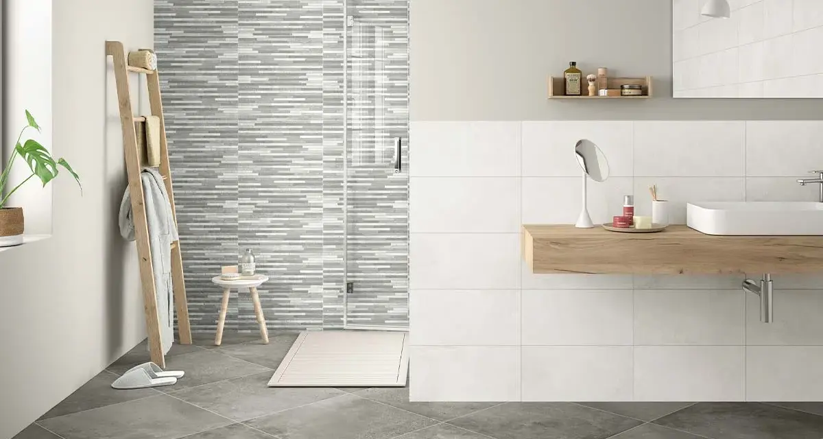 Baño moderno con ducha de azulejos grises y blancos. Aprende como limpiar azulejos baño para mantenerlo impecable.