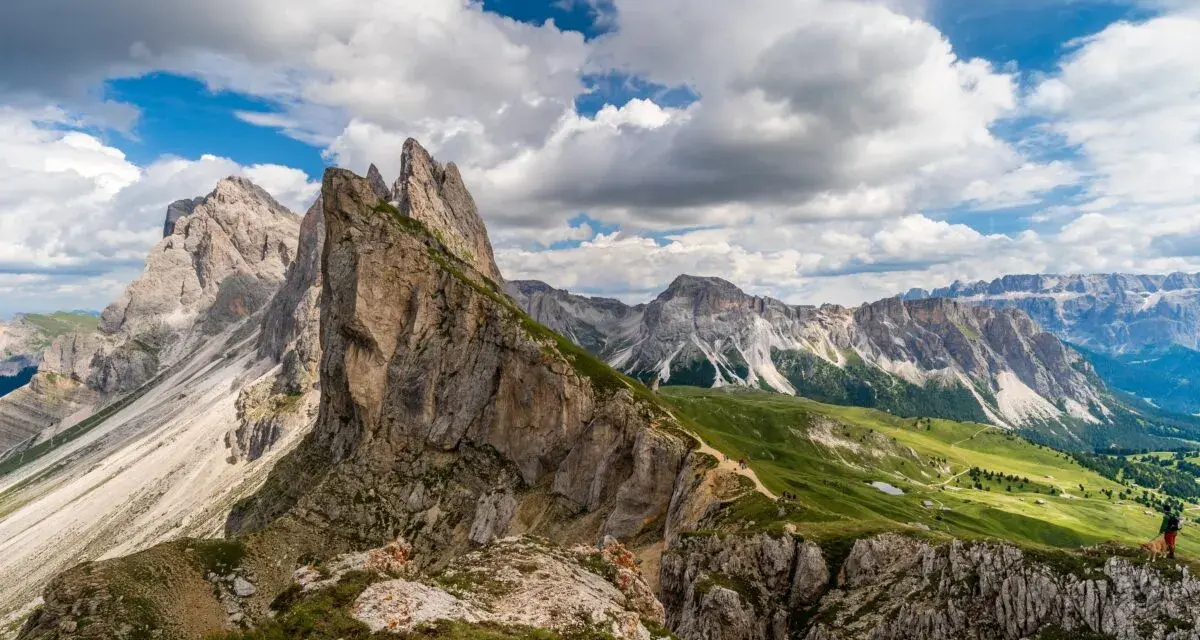 Majestatyczne szczyty Dolomitów w Val Gardena, zielone zbocza i malownicza ścieżka dla turystów.