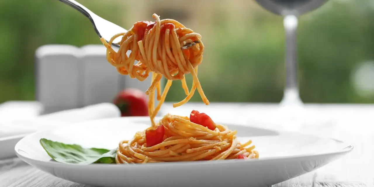 Widok na talerz z makaronem spaghetti i pomidorkami, idealny do rozważań, jakie wino do carbonary.
