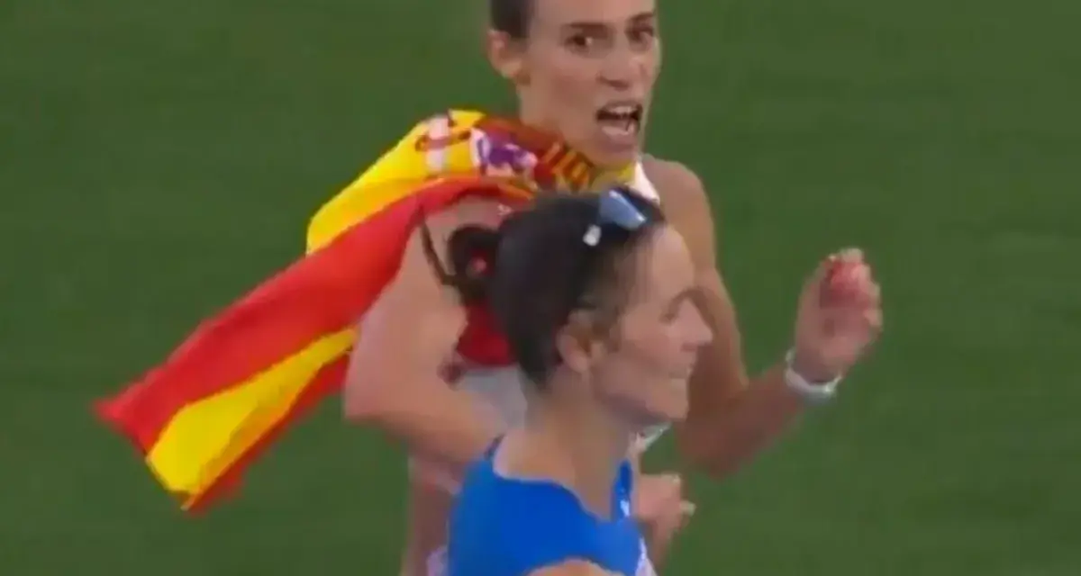 Laura García Caro celebra su victoria en atletismo, ondeando la bandera española con orgullo.