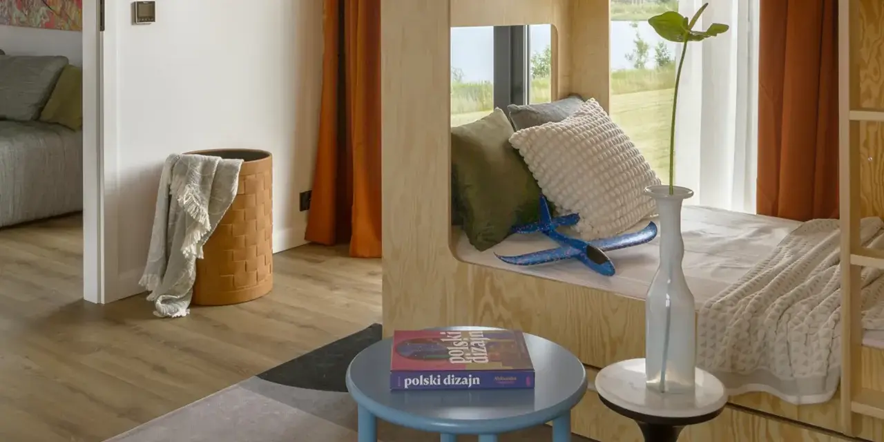 Un lit superposé dortoir maternelle en bois, avec des coussins douillets et un avion bleu pour l'aventure.