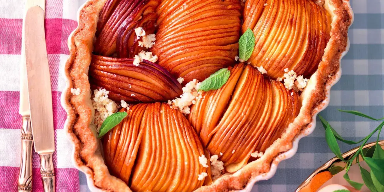 Torta pesche e amaretti con frutta caramellata e sbriciolata croccante, guarnita con menta fresca.