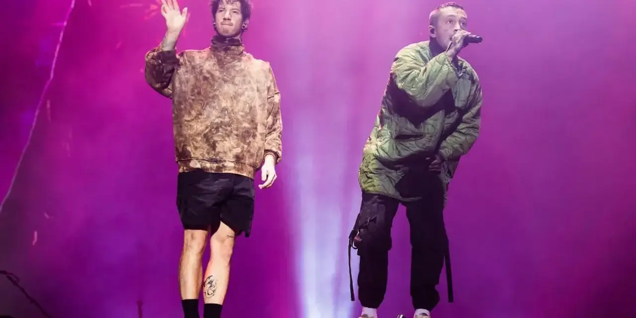 Tyler Joseph i Josh Dun z twenty one pilots na koncercie. Jeden wita publiczność, drugi śpiewa.