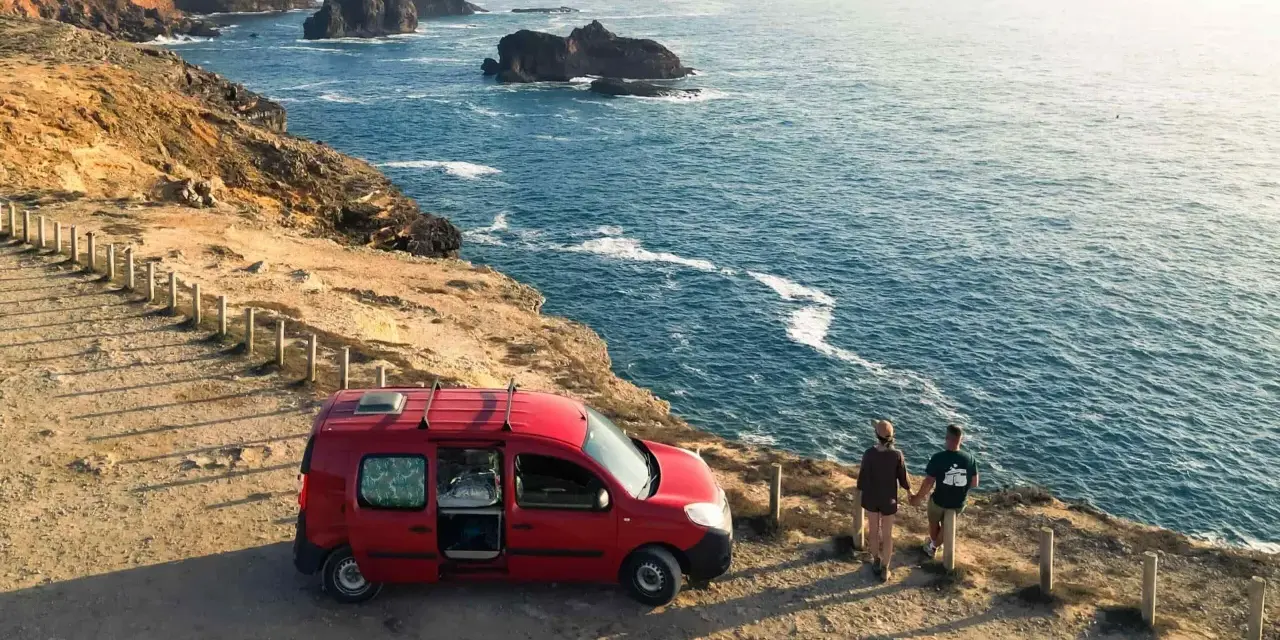 Para z kamperem na klifie w Portugalii, podziwiająca ocean. Niezapomniana podróż kamperem po Portugalii.