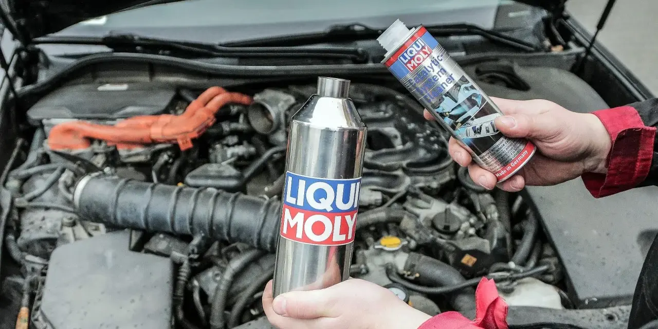Dwie ręce trzymają preparaty Liqui Moly, sugerując jak wyczyścić katalizator domowym sposobem.