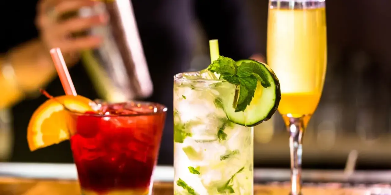 Mojito na białym rumie kontra Mojito na ciemnym. Trzy drinki: czerwony z pomarańczą, zielony z ogórkiem i żółty.