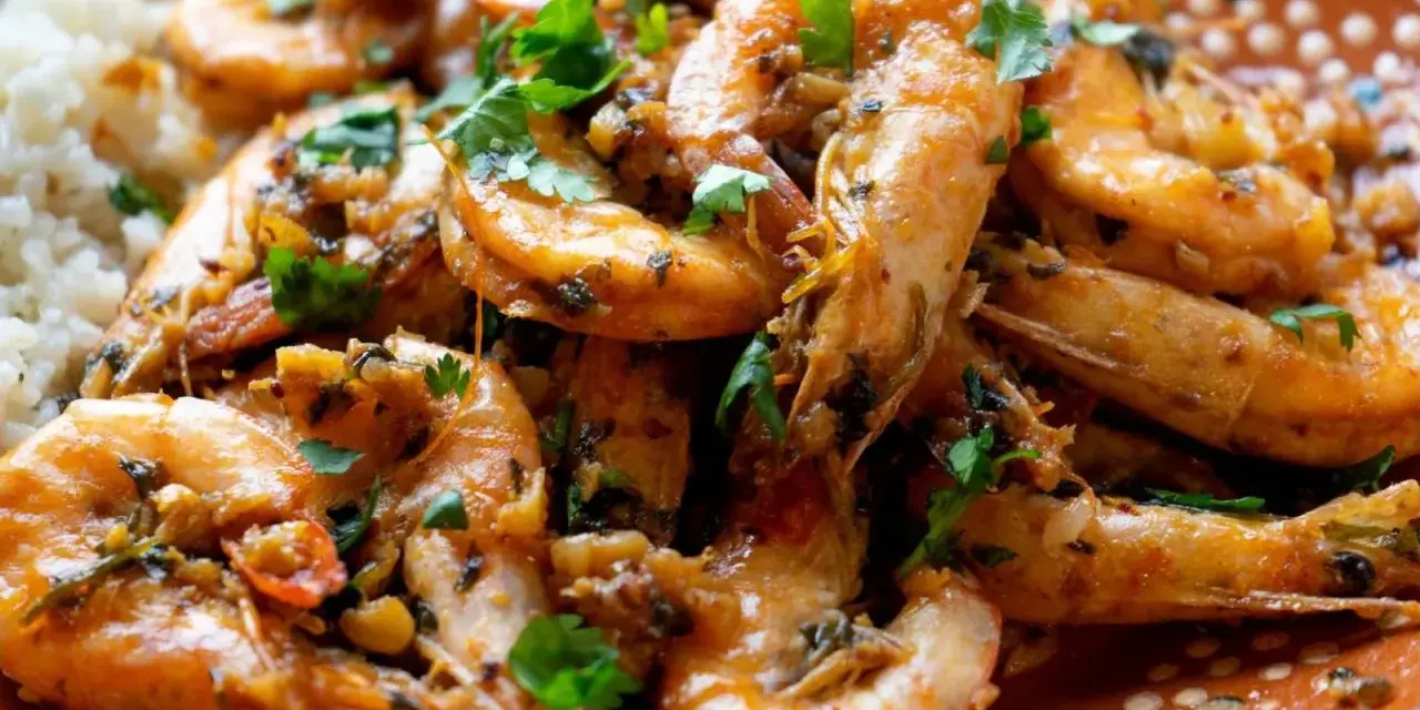 Langostinos en salsa, jugosos y llenos de sabor, servidos con arroz blanco. Un plato que invita a disfrutar.