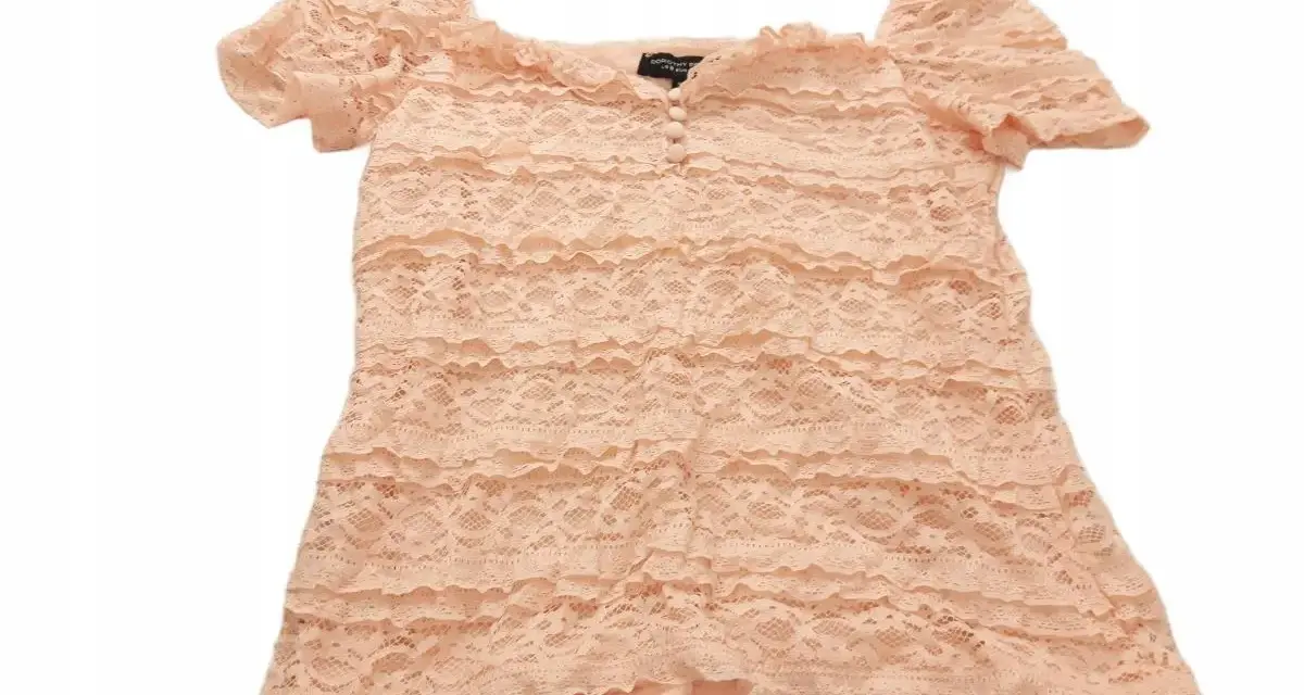 Brzoskwiniowa bluzka z koronki z falbankami i guzikami. To uroczy element garderoby od Dorothy Perkins, marki znanej z modnych ubrań.