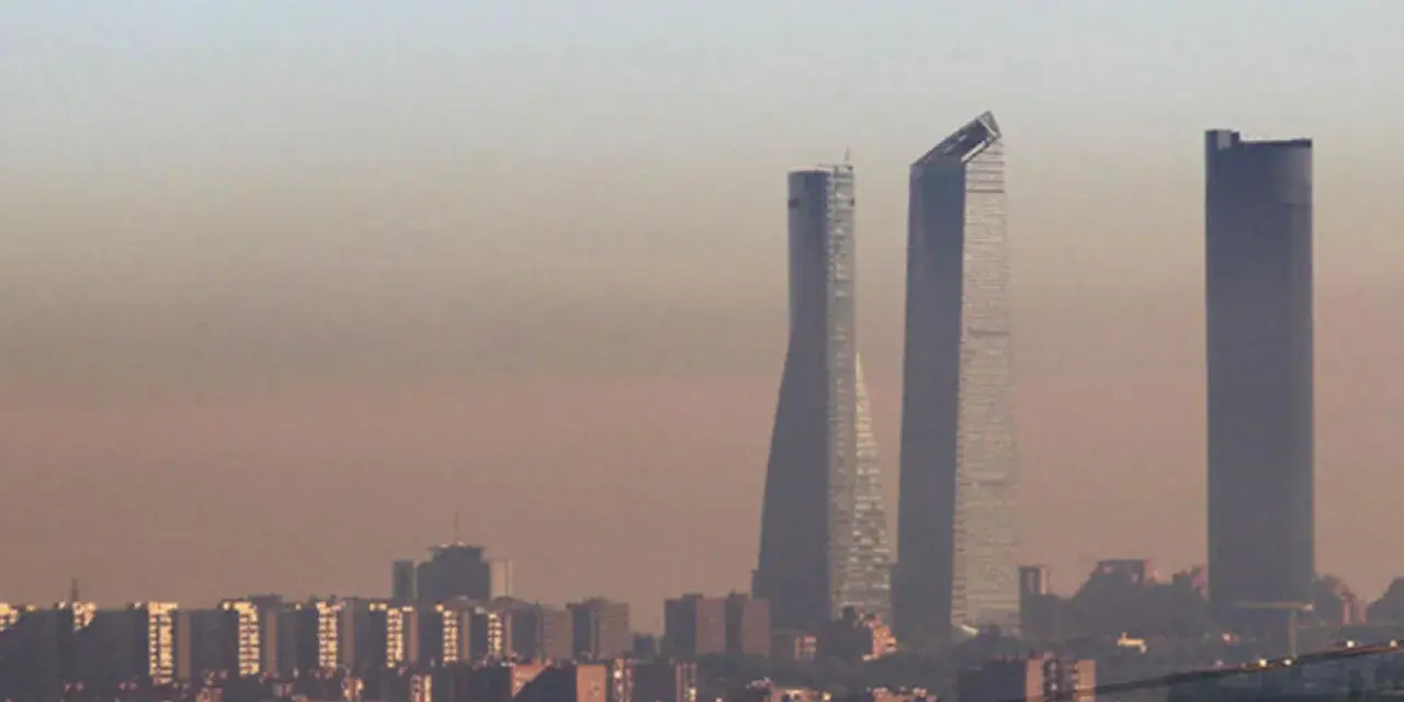 Edificios altos se alzan en una bruma densa, sugiriendo una ciudad mas contaminada del mundo.