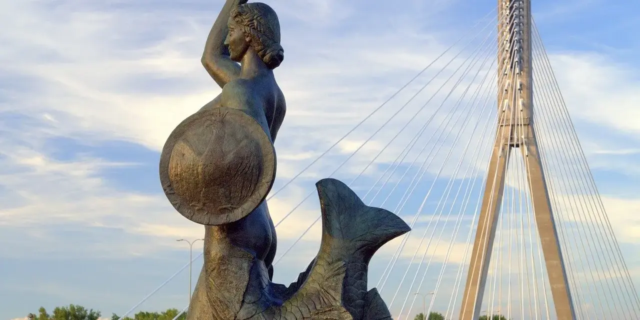 Syrenka Warszawska z mieczem i tarczą, symbol legendy o syrence warszawskiej, na tle nowoczesnego mostu.