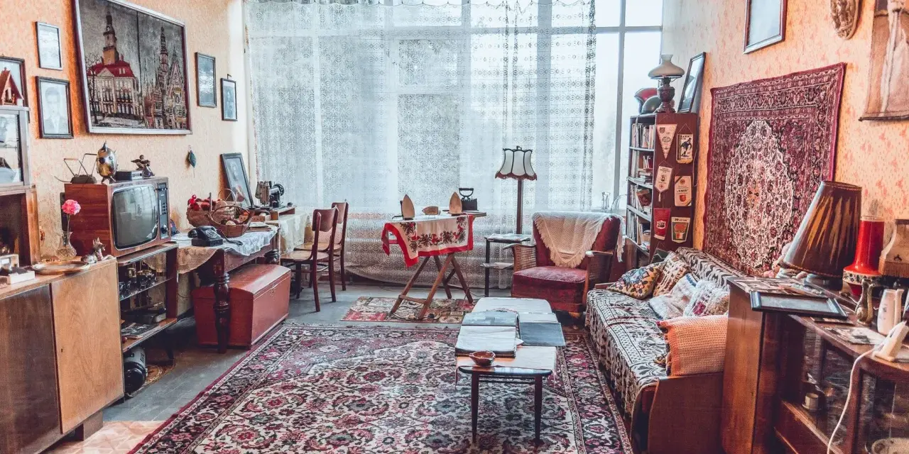 Wnętrze pełne nostalgii, jak w muzeum sentymentów. Stare meble, telewizor, dywany i bibeloty tworzą przytulną atmosferę.