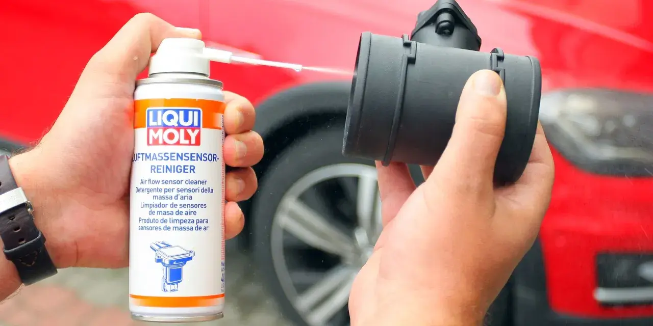 Czyszczenie przepływomierza: ręka trzyma puszkę preparatu Liqui Moly i aplikuje go na element.
