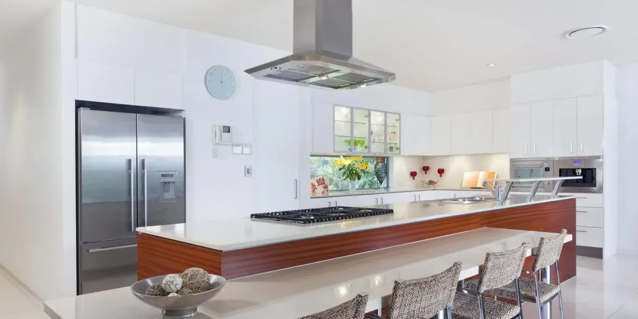 Cocina moderna con isla, electrodomésticos de acero inoxidable y encimera de cuarzo. Ideal para calcular el reforma cocina precio aproximado.