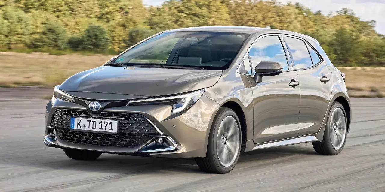 Grauer Toyota Corolla 2.0 Hybrid fährt auf Straße. Mögliche Probleme mit dem Hybridantrieb sind hier kein Thema.