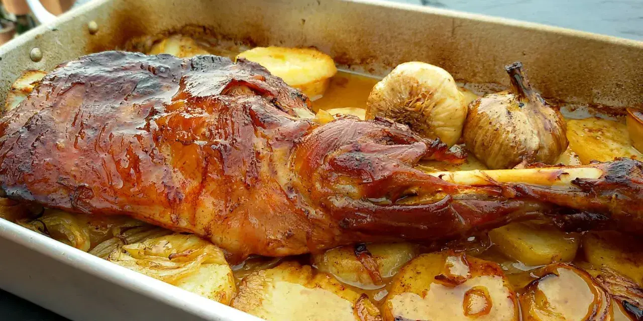Paletilla de cordero asada al horno con patatas y ajos.