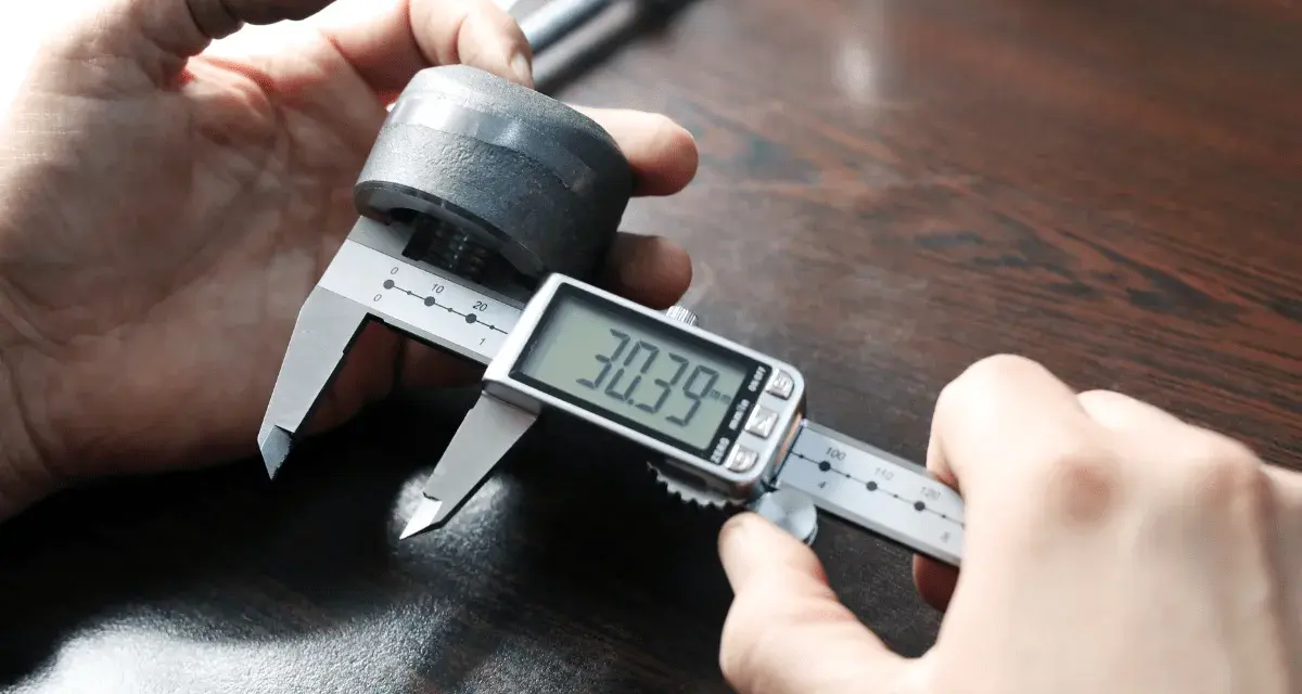 Precyzyjne pomiary: jak mierzyć suwmiarką cyfrową element metalowy, odczyt 30.39 mm.