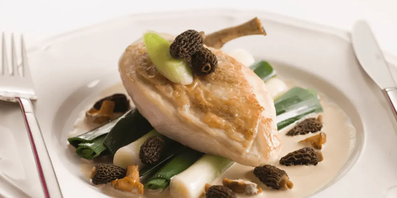 Un délicieux poulet aux morilles, servi avec des poireaux tendres dans une sauce crémeuse.