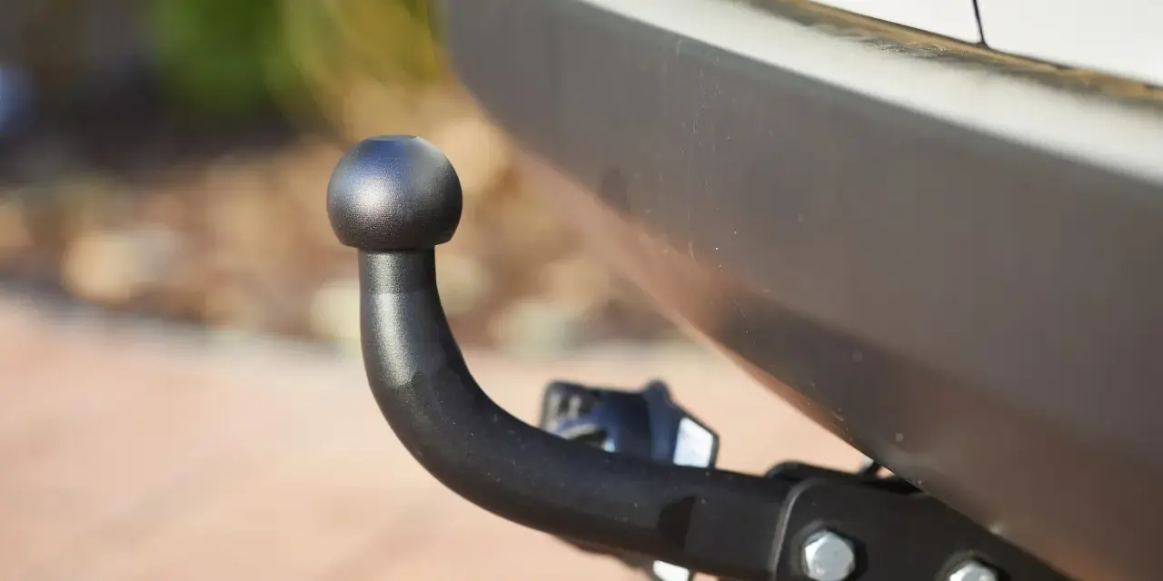 Gancio traino nero montato sul paraurti di un'auto, pronto per il traino secondo il codice della strada.