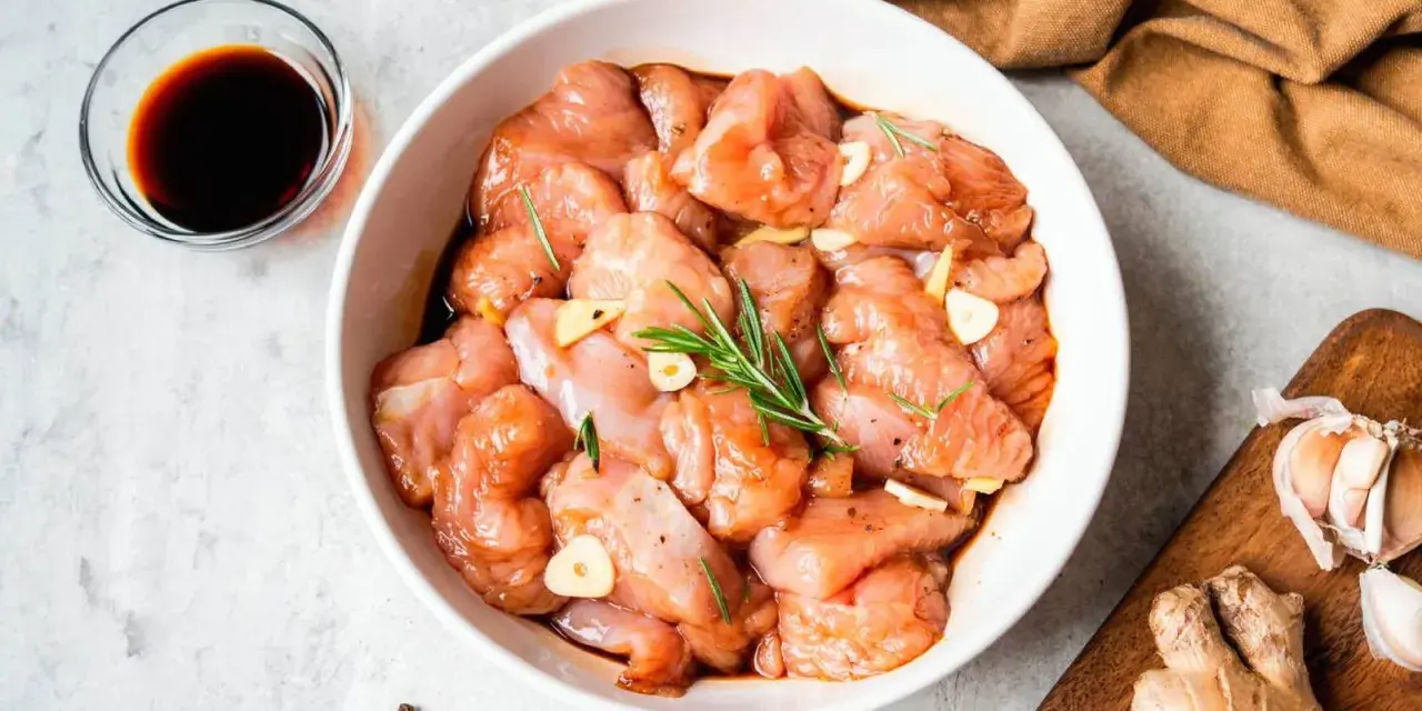 Troceado de pollo marinado con ajo y romero, listo para deliciosas recetas.