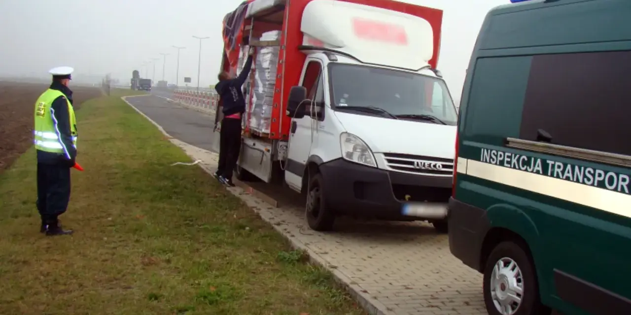 Kontrola drogowa: funkcjonariusz w kamizelce odblaskowej kieruje ruchem, obok biała ciężarówka z ładunkiem. Czy kierowca ma prawo jazdy kat b do 7,5 tony?