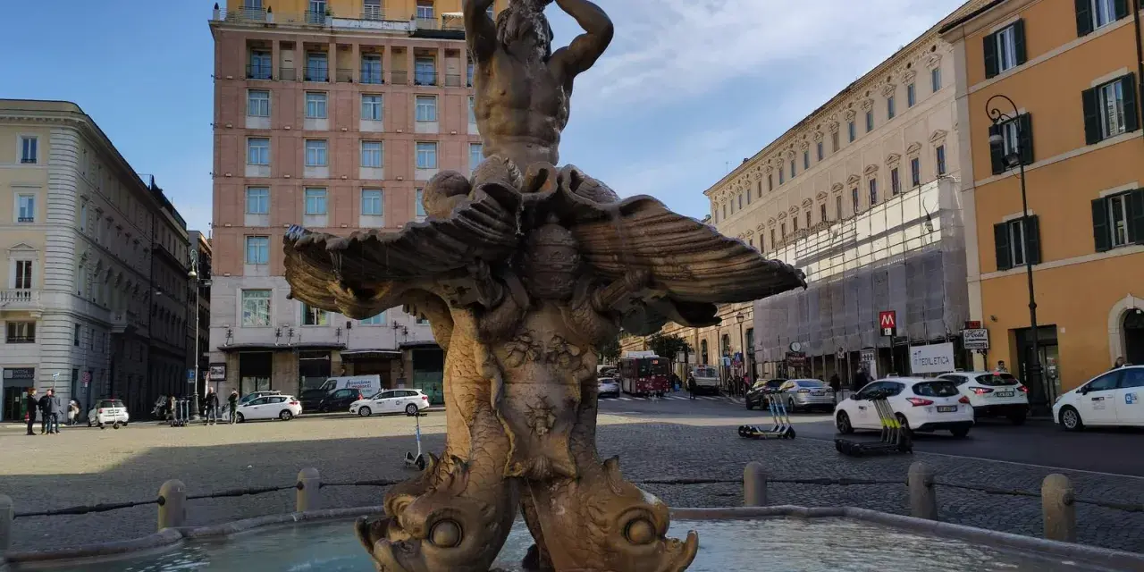 Fontana del Tritone in Piazza Barberini, Roma, con edifici storici e traffico sulla via dei Cappuccini.