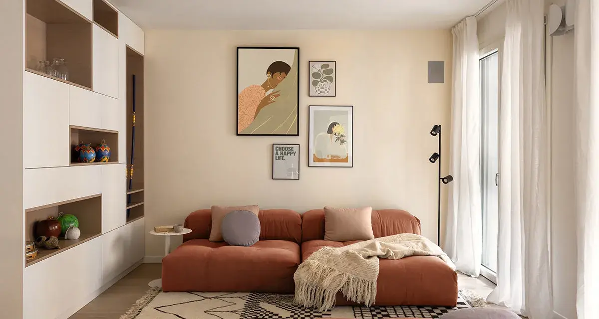 Un soggiorno moderno con divano color terracotta e tappeto geometrico. L'arredamento è pensato per abbinare tappeto e divano, creando un ambiente accogliente.