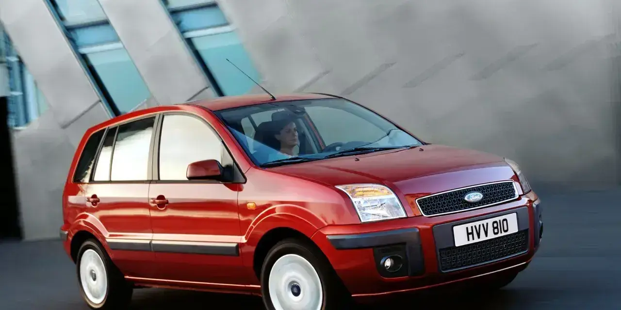 Czerwony Ford Fusion 1.4 benzyna w ruchu miejskim. Elegancka sylwetka i nowoczesny design.