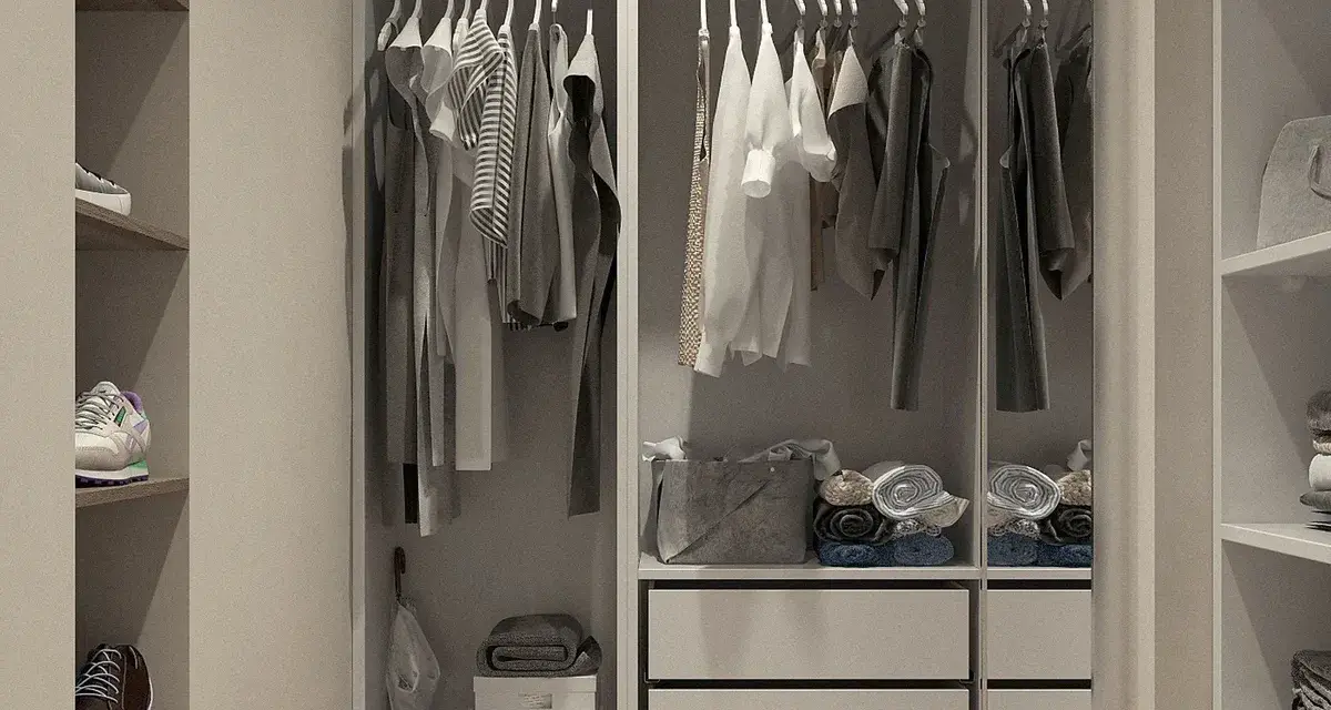 Un impecable fondo de armario mujer con ropa colgada y doblada, zapatos en estantes y accesorios organizados.