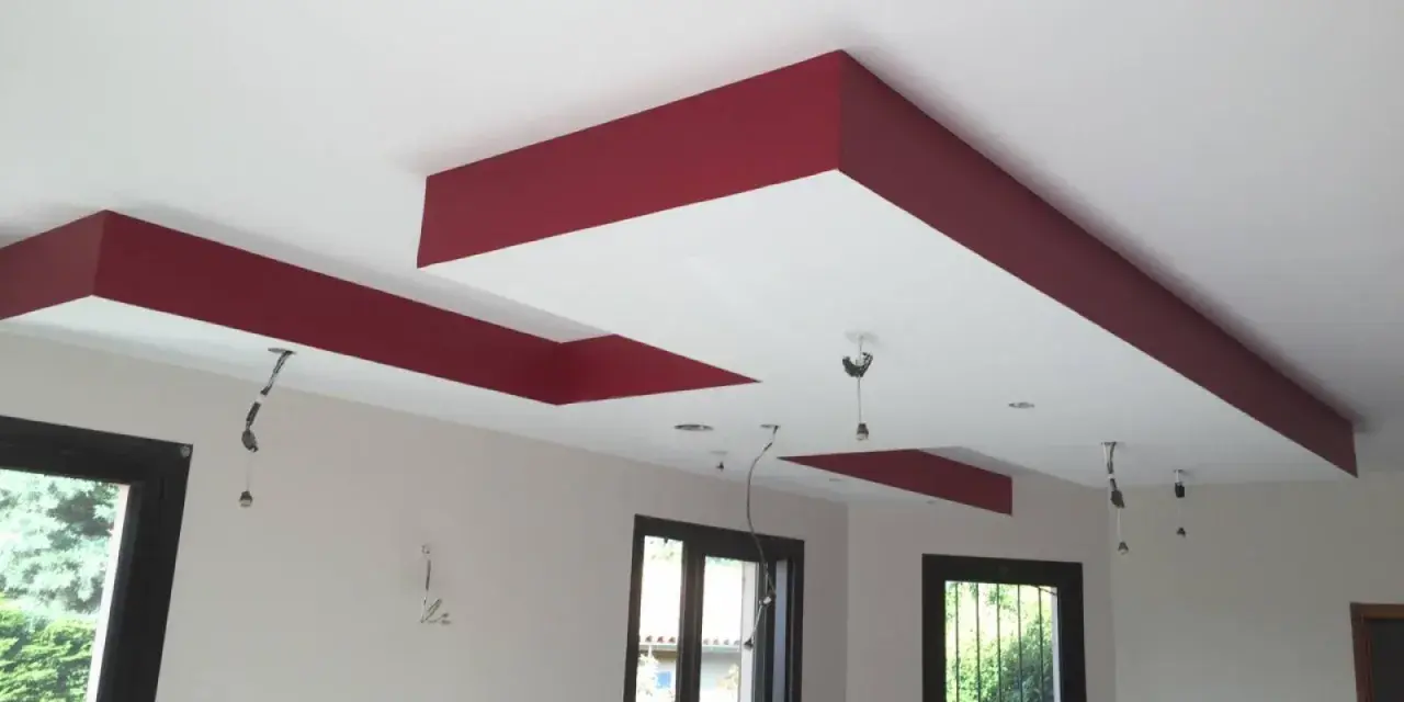 Plafond moderne avec caisson décoratif rouge et emplacements pour spots.