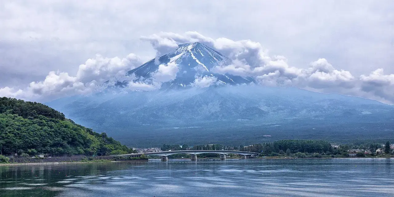 Majestatyczny Fudżi wyłania się z chmur nad jeziorem. Zastanawiasz się, ile się leci do Japonii, by zobaczyć ten widok?