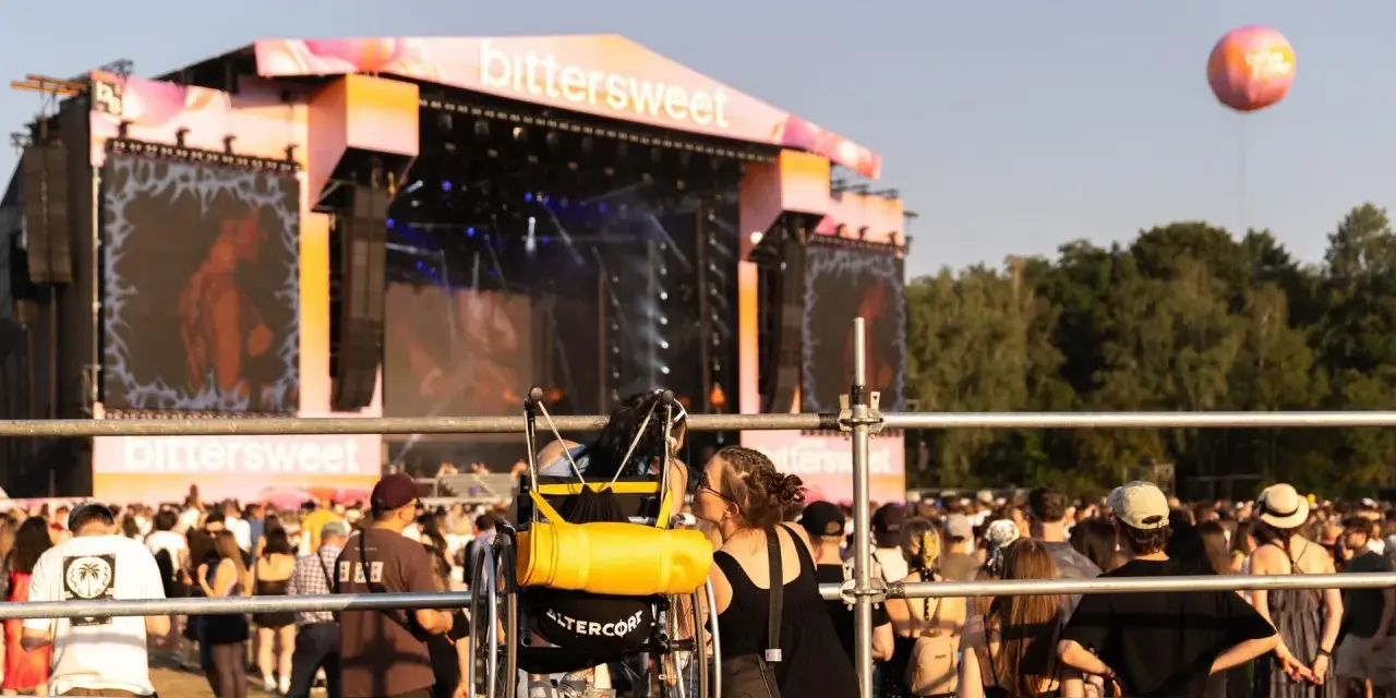 Dwie osoby, jedna na wózku, dzielą intymną chwilę na festiwalu bittersweet.