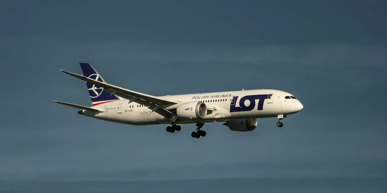 Samolot LOT Polish Airlines z bagażem podręcznym w locie, zbliżający się do lądowania.