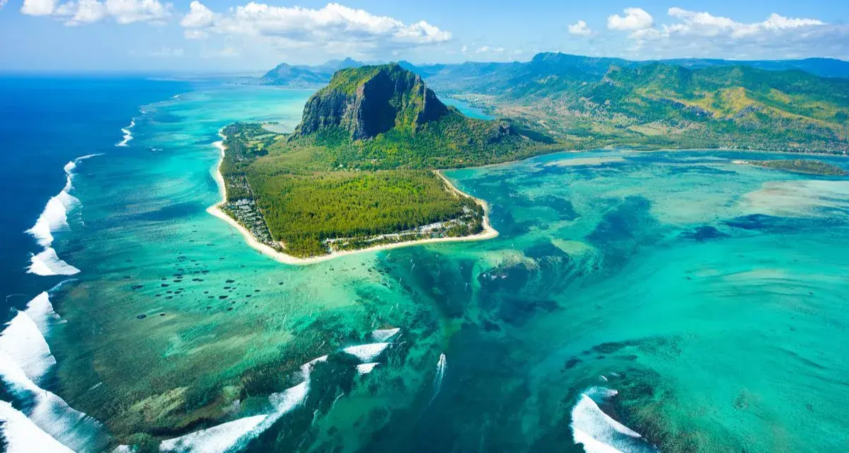 Widok z lotu ptaka na Mauritius: turkusowa laguna, góra Le Morne Brabant i białe fale rozbijające się o rafę. Idealne miejsce na loty na Mauritius.