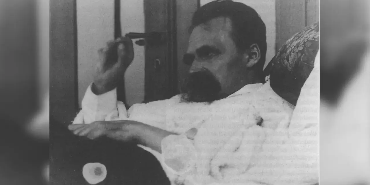 Nietzsche, zamyślony, w białej koszuli, z charakterystycznym wąsem. Jego poglądy kształtują obraz myśli.