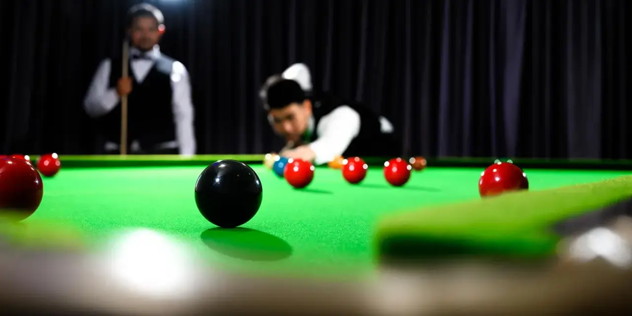 Gracze w skupieniu rozgrywają mecz snookera, zbliżając się do zwycięstwa w snooker mistrzostwa świata.