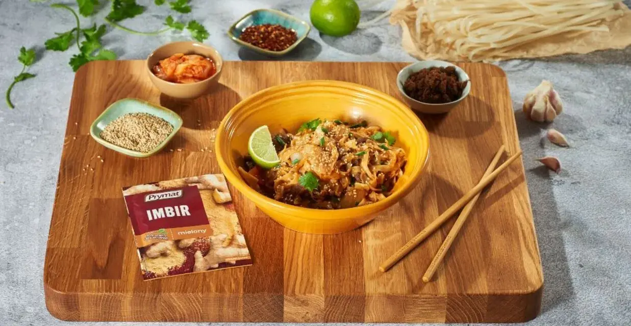 Curry z kurczakiem czy stir-fry z wołowiną? Na desce składniki do dania z makaronem ryżowym, imbir, sezam, chili, czosnek i limonka.