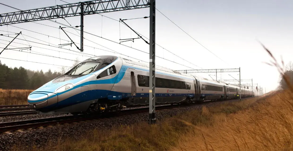 Nowoczesny Pendolino pędzi po torach, symbolizując rosnącą prędkość pociągów w Polsce.