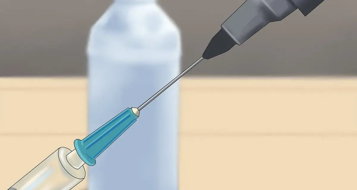 Jeringa inyectando líquido en la punta de un rotulador seco para revivirlo.