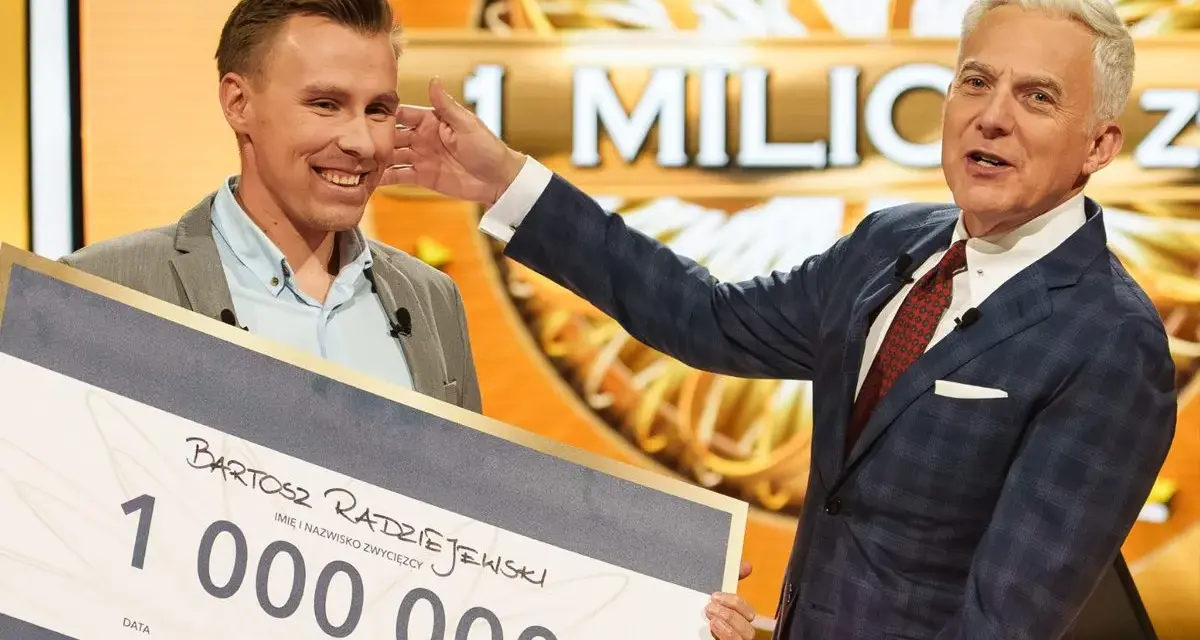 Bartosz Radziejewski, który wygrał milion w Milionerach, odbiera czek z nagrodą od Huberta Urbańskiego.